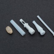 Here are some examples of Duracon® (POM) and Teflon® (PTFE) micro-processed parts compared to the size of Genmai's rice grain.